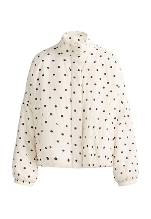 Weiße Steppjacke mit schwarzen Punkten, hohem Kragen, langen Ärmeln mit elastischen Bündchen und vorderer Druckknopfreihe.