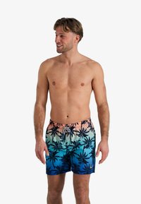 Shorts de bain pour hommes avec un dégradé allant du rose au bleu, ornés d'imprimés de palmiers noirs. Fabriqués en tissu léger et à séchage rapide.