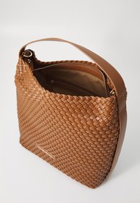 Brunnet flettet lærveske med en glatt skulderstropp. Interiøret har en glidelåslomme. Strukturert overflate og slankt design.