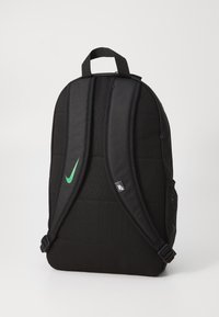 Zaino nero con schienale e spallacci imbottiti, caratterizzato da un logo verde Nike swoosh, tasca laterale in rete e clip regolabili. Tessuto resistente.