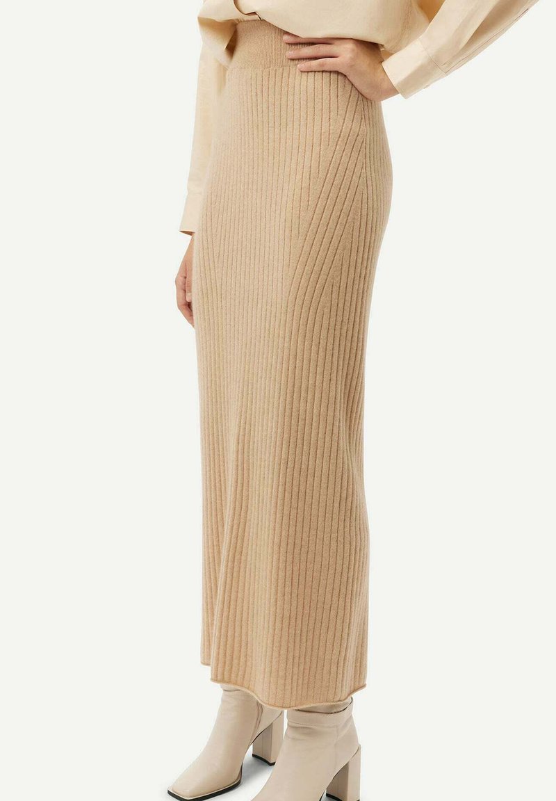 Ribbade beige stickade kjol med en åtsittande midja som sträcker sig till ankellängd. Bärs med krämfärgade klackade ankelskor.