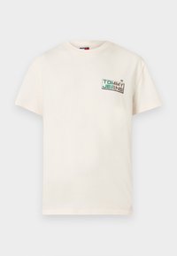 Βαμβακερό μπλουζάκι χρώματος κρέμα με κοντά μανίκια και στρογγυλή λαιμόκοψη, με ένα λογότυπο μπροστά σε πράσινο και μαύρο κείμενο.