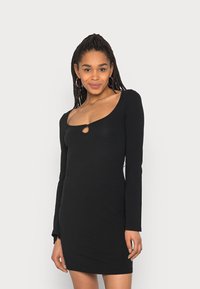 Vestido preto de manga longa feito de tecido elástico, com decote redondo e um pequeno recorte no centro, apresentando uma silhueta ajustada.