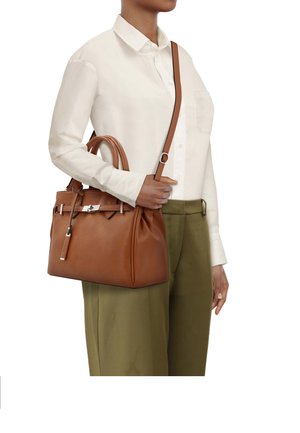 Sac à main en cuir marron à forme structurée, avec deux poignées supérieures, bandoulière réglable, ferrures argentées et détail de logo discret.