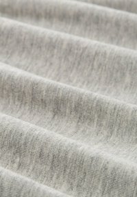 Hellgrauer Stoff mit weicher Textur, der horizontale Rippmuster und subtile Farbvariationen aufweist.