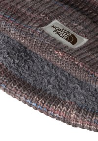 Berretto lavorato a maglia grigio e rosa con una fodera in pile e un'etichetta bianca cucita con il logo The North Face.