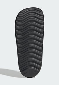Černá gumová podrážka s vlnitou texturou, mají hluboké drážky pro trakci. Zakřivený tvar na špičce a patě pro ergonomické uchycení.