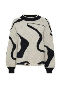 Gebreide trui in beige met zwarte abstracte patronen, ronde hals, en geribbelde zwarte manchetten en onderkant. Heeft een ontspannen, oversized pasvorm.