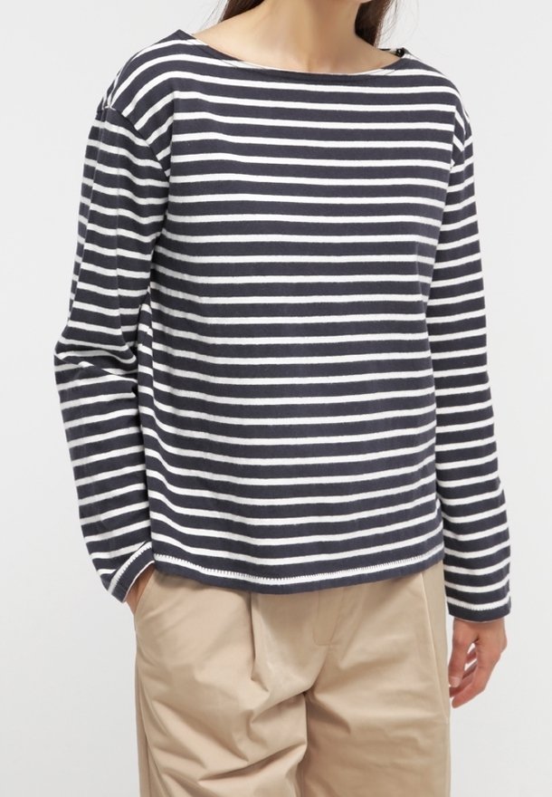 Haut à manches longues rayé bleu marine et blanc avec un large col et une coupe décontractée. Le tissu est doux avec une texture lisse.
