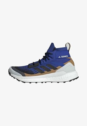 Chaussure de randonnée haute Adidas Terrex bleu, noir, marron et blanc avec semelle texturée et fermeture à lacets.