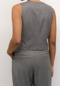Grau gestreifter ärmelloser Oberteil mit einem klaren Design. Weicher Stoff mit strukturiertem Schnitt, in kürzerer Länge und mit hohem Rundhalsausschnitt.