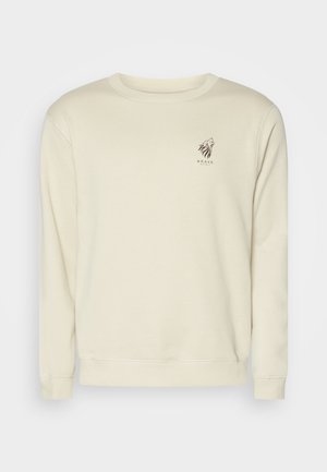 Felpa beige con maniche lunghe, polsini a costine e collo tondo. Presenta una piccola grafica di un leone marrone e testo sul petto. Tessuto morbido.