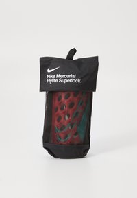 Nike Mercurial Flylite Superlock krepšys turi juodą audinį išorėje, permatomą panelę, rodantį raudoną ir melsvą dizainą, taip pat viršutinę rankeną.