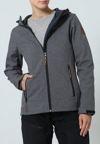 Veste grise à fermeture éclair avec capuche, dotée d'un tissu texturé, d'accents noirs et de détails en cuir marron sur les manches et les poches.