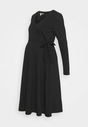 Musta odottavien äitien kietaisumekko pitkillä hihoilla, V-kaula-aukolla ja vyötärösoljella. Valmistettu pehmeästä kankaasta, jossa on valuva hame mukavuutta varten.