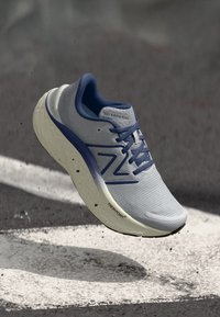 Šviesiai mėlyni sportiniai bateliai su tinkliniu paviršiumi, tamsiai mėlynomis akcentais ir balta, tekstūruota išorine dalimi su "Fresh Foam" ženklinimu.
