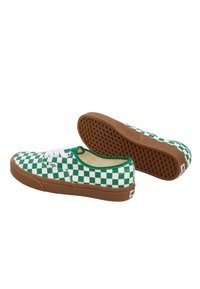 Des chaussures à enfilage à motif pied-de-poule vert et blanc avec des semelles en caoutchouc marron, dotées de lacets blancs et d'un col rembourré pour le confort.