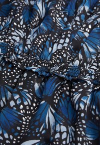 Tissu noir avec des motifs d'ailes de papillon en bleu, bleu clair et blanc, présentant des coutures élastiques froncées au centre.