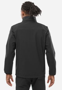 Veste imperméable noire avec un col haut, des épaules sans coutures et des poignets élastiques. La vue arrière montre une texture lisse et une coupe ajustée.