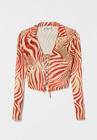 Haut court à manches longues rouge et beige avec un motif à rayures zèbre, un décolleté en V et un détail à lacets sur le devant. Texture de tissu lisse.