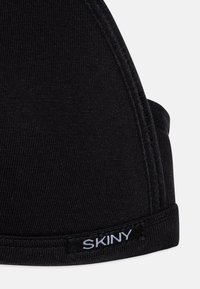 Svart stretch-stoff-bh med ribbet tekstur, justerbare stropper og et merke med "SKINY" på båndet.