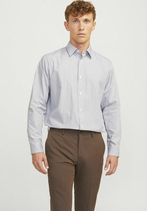 Heren overhemd met knopen in het wit met blauwe verticale strepen, lange mouwen en een klassieke kraag. Gecombineerd met een paar bruine, op maat gemaakte broek.