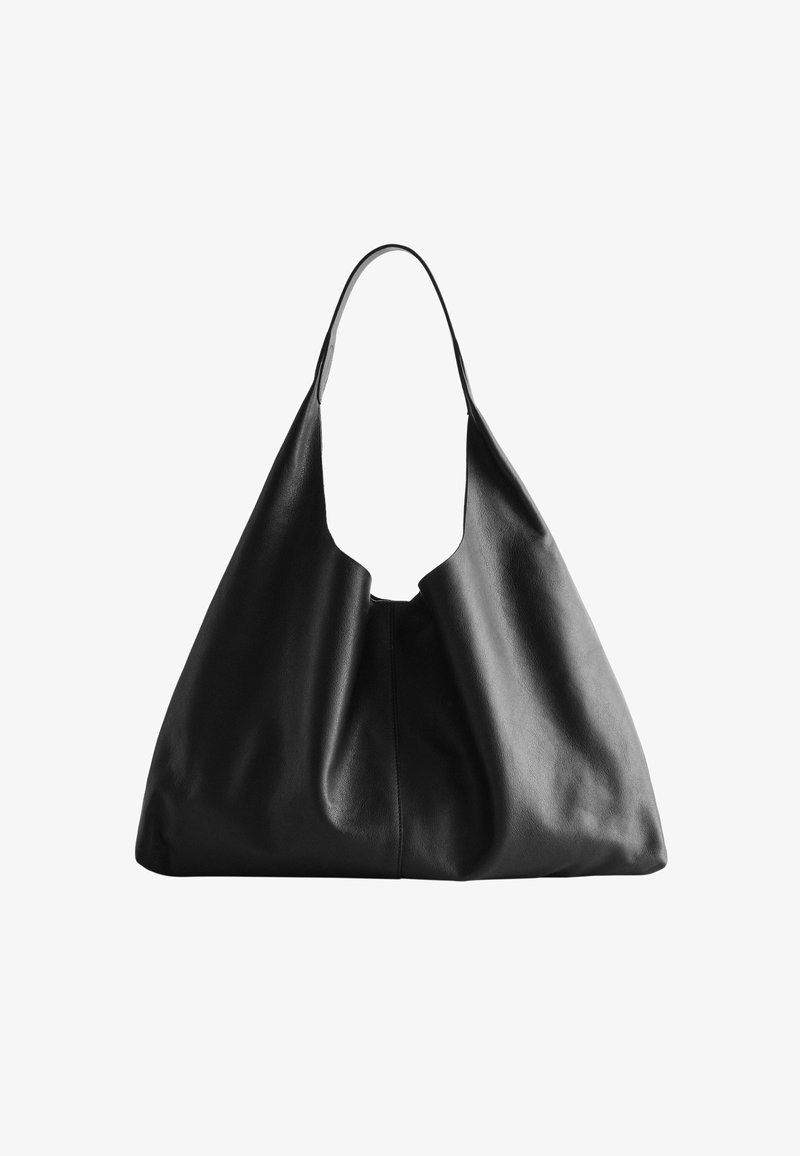 Sac hobo en cuir noir avec une forme douce et désossée, doté d'une large anse supérieure et d'un design sans couture sans matériel visible.