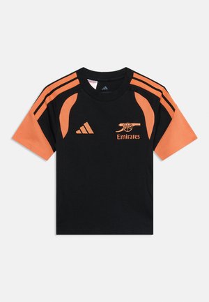 Czarna i pomarańczowa sportowa koszulka z krótkim rękawem z logo Adidas i emblematem klubu piłkarskiego Arsenal z sponsorem Emirates na piersi.