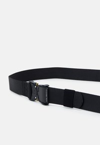 Ceinture en nylon noir avec une finition texturée, dotée d'une boucle durable et d'un design réglable pour un ajustement sécurisé. Accentuée de détails en or.
