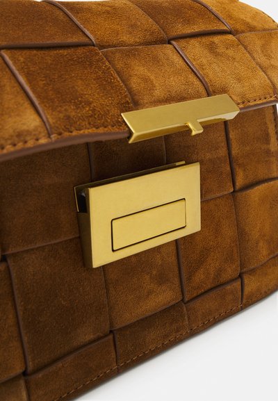 Bolso de ante marrón con textura trenzada, que presenta un cierre rectangular dorado y plano. Acabado suave con detalles de costura ordenados.