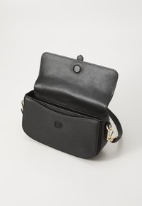 Black leather crossbody bag with a smooth texture, magnetic flap closure, gold-tone hardware, and an open interior.
