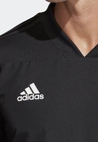Camiseta deportiva negra de adidas con diseño de cuello en V, tejido texturizado y logo blanco característico en el lado izquierdo del pecho.