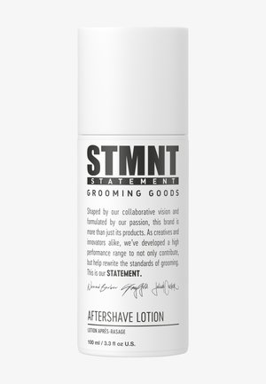 Witte cilindrische fles aftershave lotion met zwarte tekst; bevat merknaam, productbeschrijving en handtekeningen op het etiket.