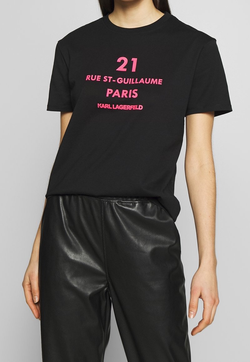 Czarna bawełniana koszulka z odważnym różowym napisem: "21 RUE ST-GUILLAUME PARIS KARL LAGERFELD." Krótkie rękawy, okrągły dekolt, luźny krój.