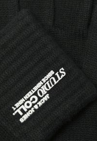 Guantes de punto negros con textura acanalada y un logo plateado. El diseño es sencillo con una apariencia acogedora, adecuada para el clima frío.