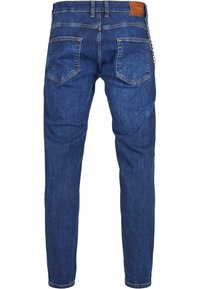 Mørkeblå denim skinny jeans med en glat tekstur, fem lommer og et lædermærke på bagsiden af taljen. Kædedetalje på siden.