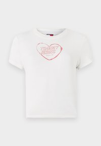 Bala īsa piedurkne T-kreklā, kas izgatavota no kokvilnas, ar rozā sirds grafiku, kurā iekļauts teksts "TOMMY JEANS" un "Since 85". Standarta izmērs.