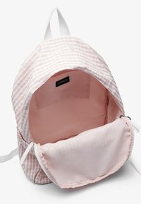 Pink striped backpack with a smooth interior. Features a single compartment, top handle, and zip closure. Material is lightweight fabric.
