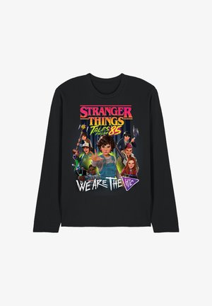 Black long-sleeve shirt with colorful "Stranger Things Tales from 85" text and cartoon characters holding weapons, with "We Are The H.I.C" below.