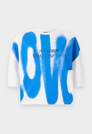 Hvit bomull t-skjorte med blå spraymaling-stil "KJÆRLIGHET" tekst. Korte ermer, avslappet passform, rund hals, med grafisk design og moderne typografi.