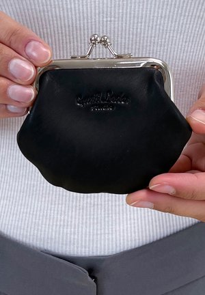 Black leather coin purse with a silver-tone clasp, rounded shape, and subtle embossed branding on the front. Smooth texture and compact size.