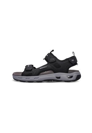 Sort og grå udendørs sandal med justerbare remme og polstret sål designet til komfort og holdbarhed.