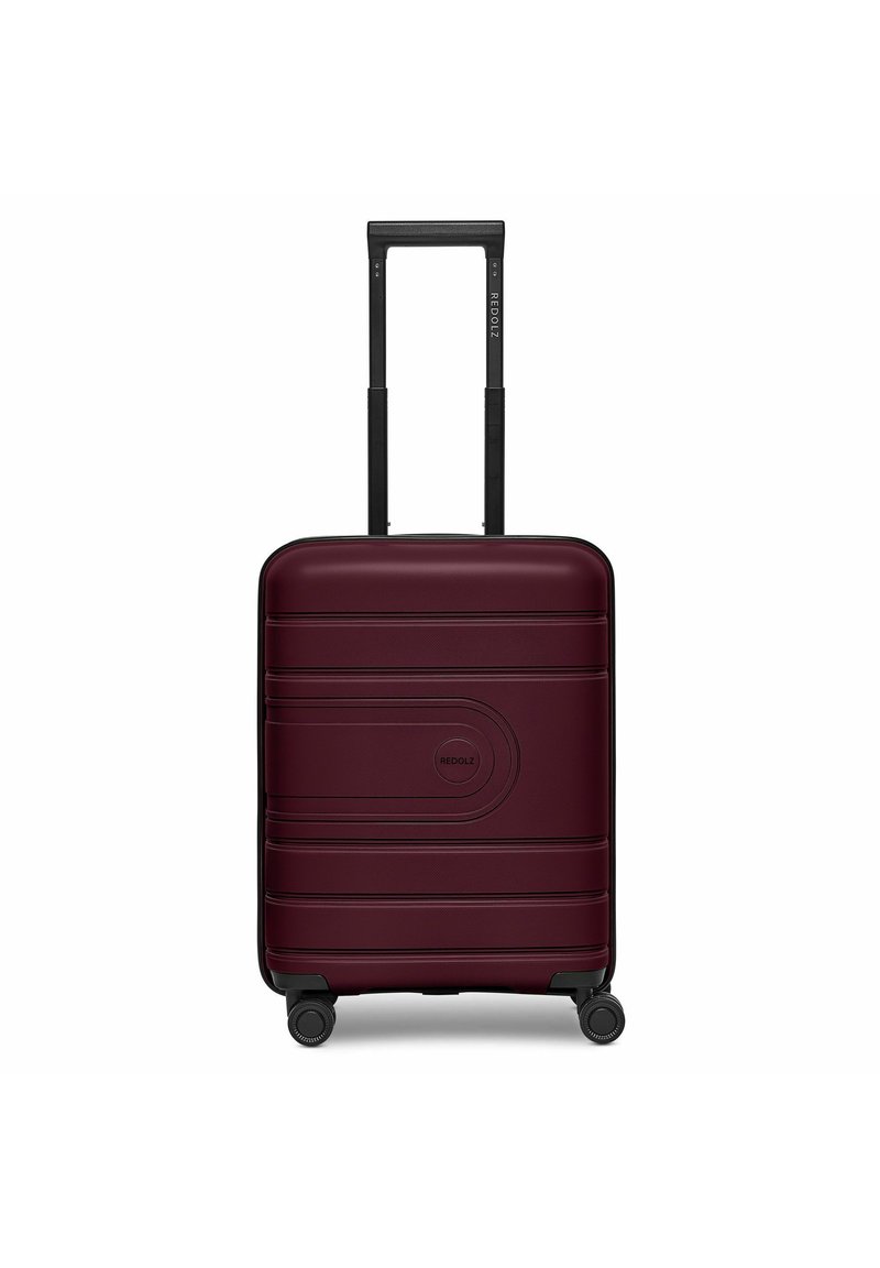 Hard-shell koffer in bordeauxrood met een gestructureerd oppervlak, logodetail, dubbele telescopische handgreep en vier zwarte wielen voor mobiliteit.