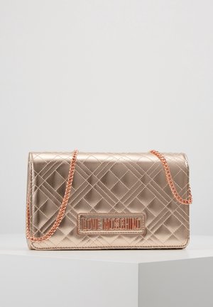 Quiltet rosa guld crossbody taske med kæderem og "LOVE MOSCHINO" logoplade foran, vist på en hvid piedestal.
