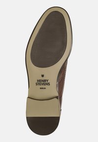 Suola di scarpa in pelle marrone con texture a coste; presenta un bordo beige e le iscrizioni "HENRY STEVENS" e "BERLINO". Design elegante e robusto.