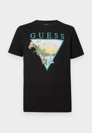 Sort T-shirt med turkis "GUESS" logo over et trekantet design med tropiske planter, blomster, sejlbåde og små flyvemaskiner.