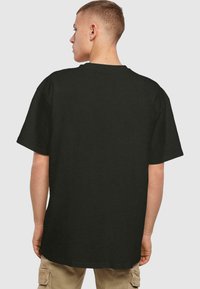 Zwarte katoenen t-shirt met korte mouwen, losse pasvorm en een ronde hals. Glad textuur en geen zichtbare logo's of graphics.