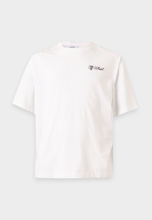 Homme portant un t-shirt blanc Off-White et un pantalon de jogging noir avec un grand texte Off-White, debout les mains dans les poches sur un fond uni.