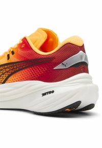 Baskets de sport avec une tige en maille dégradée orange et rouge, un col rembourré, un accent logo argenté, et une semelle blanche épaisse avec une semelle extérieure noire texturée.