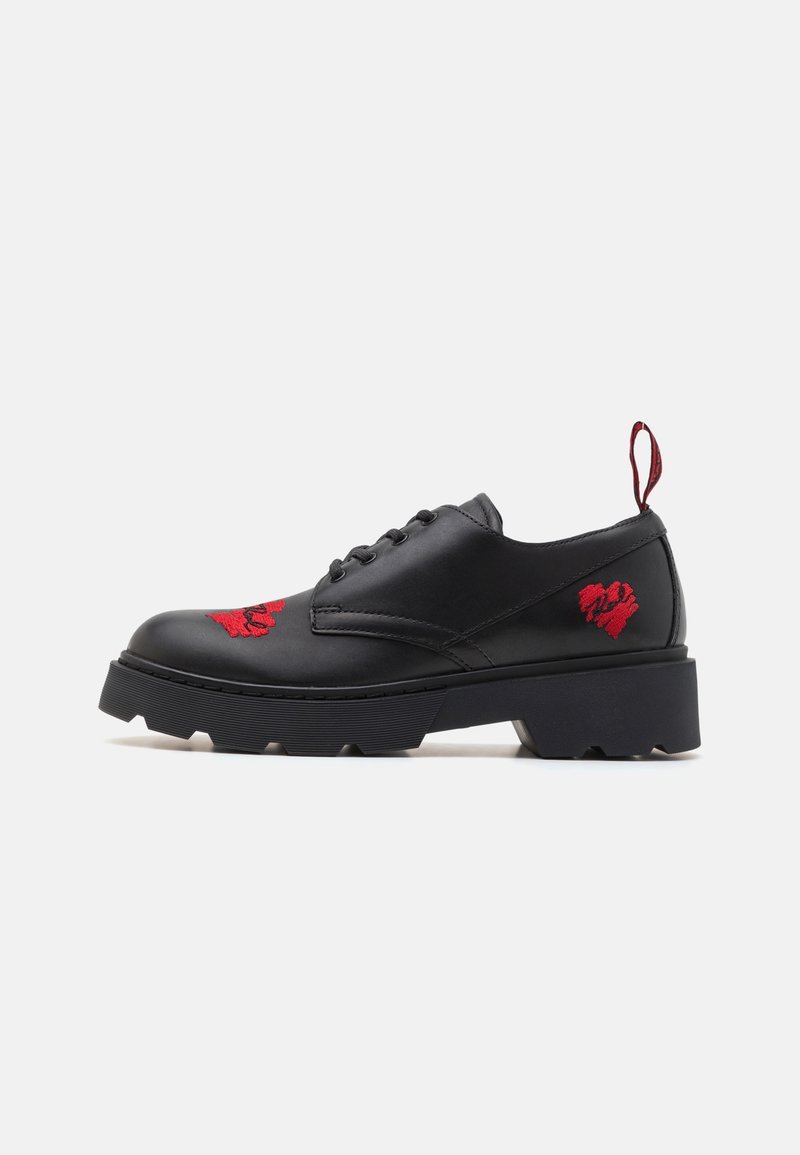 Chaussures à lacets en cuir noir ornées d'un motif brodé rouge, avec une semelle épaisse noire et une languette rouge à l'arrière.